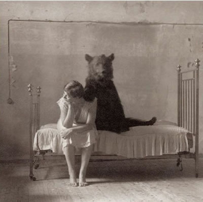 BuzzfeedB&W10 A woman sitting on a bed with a bear behind her